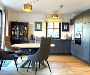 a kitchen with a wooden table and chairs at Ferienhaus Oogenstern USEDOM -ruhige Lage-Fischerdorf Zirchow in Zirchow