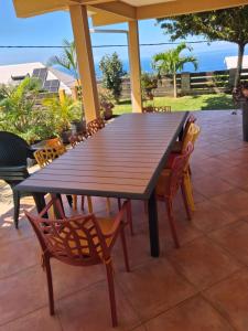 a wooden table and chairs on a patio at ChezRoselineetChritian in Les Avirons