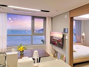 a hotel room with a bedroom with a view of the ocean at 오늘도광안씨 in Busan
