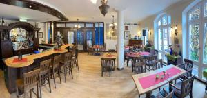 a restaurant with tables and chairs and a bar at Akzent Hotel Höltje in Verden