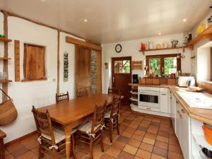 una cocina con mesa de madera y sillas. en Heritage Holiday Home in Roumont en Roumont
