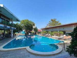 a large blue swimming pool in front of a building at Tamnan Resort Pattaya in Ban Nong Chaeng
