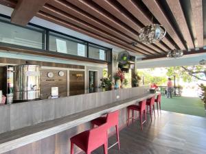 a bar with red chairs in a restaurant at Tamnan Resort Pattaya in Ban Nong Chaeng