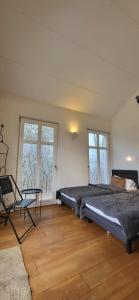 a bedroom with two beds and a chair in it at Ferienhaus an der Allee in Kalkar