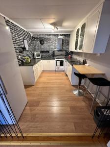 a kitchen with white cabinets and a wooden floor at Stavern Terrace in Larvik +20 photos
