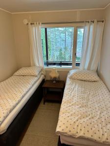 two twin beds in a room with a window at Stavern Terrace in Larvik