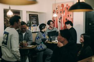 a group of people sitting at tables in a restaurant at Public Guest House in Karuizawa +16 photos