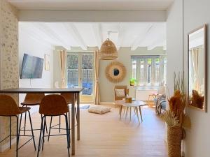 a kitchen and living room with a table and chairs at Le Balcon des Rois in Dourdan