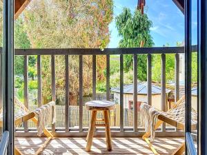 a porch with two chairs and a stool on a deck at Le Balcon des Rois in Dourdan