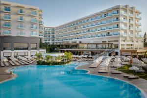 a hotel with a large swimming pool and lounge chairs at NissiBlu Beach Resort in Ayia Napa