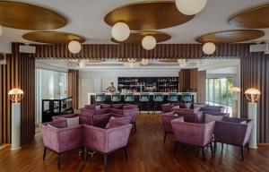 a lobby with purple chairs and a bar at NissiBlu Beach Resort in Ayia Napa