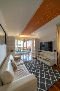 a living room with a white couch and a tv at PROMENADE Luxury View in Sarnico