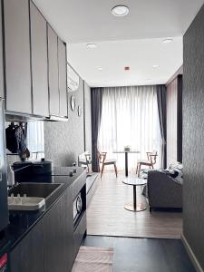 a kitchen and living room with a couch and a table at Muay Thai Apartment - Ratchada in Bangkok