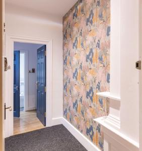 a hallway with a blue door and a floral wallpaper at 38 Bide Collective in Edinburgh +67 photos