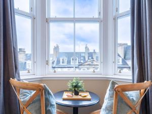 a table and two chairs in front of a window at 38 Bide Collective in Edinburgh