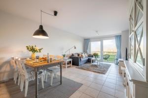a dining room and living room with a table and chairs at Port Albert by BLOSS in Nieuwpoort +20 photos
