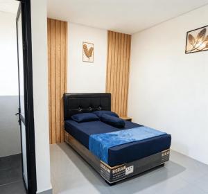 a bedroom with a bed with a blue mattress at Bale Cakra in Ngemplak