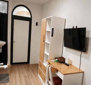 a room with a tv and a desk with a table at Bale Cakra in Ngemplak +18 photos