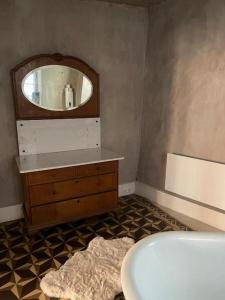 a bathroom with a mirror and a dresser and a tub at Ferienwohnung "Atelier_1" in Edenkoben