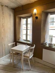 a table and chairs in a room with two windows at Ferienwohnung "Atelier_1" in Edenkoben