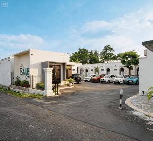 a row of buildings with cars parked in a parking lot at Bale Cakra in Ngemplak