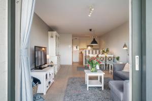 a living room with a couch and a tv at Port Albert by BLOSS in Nieuwpoort