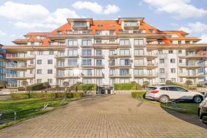 a large white building with an orange roof at Port Albert by BLOSS in Nieuwpoort
