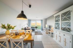 a dining room and living room with a table and chairs at Port Albert by BLOSS in Nieuwpoort