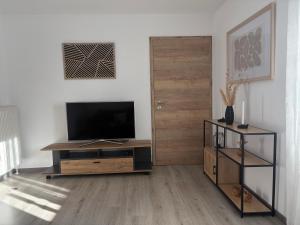 a living room with a flat screen tv on a wooden cabinet at Ferienwohnung Zaglmann in Zandt