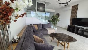 a living room with a couch and a tv at Protaras Heights- Hana in Paralimni