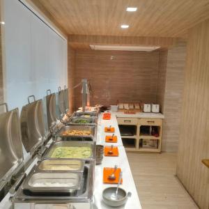 a kitchen with a long table with food on it at Ramada Tenn Ekamai in Bangkok