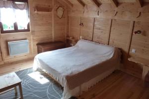 a bedroom with a bed in a wooden room at Les Bordes De Paloumières in Vicdessos