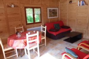 a room in a log cabin with a table and a chair at Les Bordes De Paloumières in Vicdessos