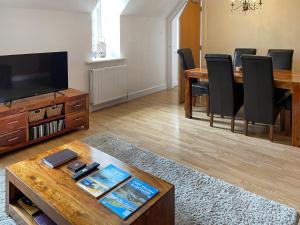 a living room with a table and a dining room at Moat House 6 - Ukc4889 in Fort Augustus