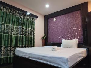 a bedroom with a bed with a green curtain at Domukha pali ghar in Chepti +32 photos
