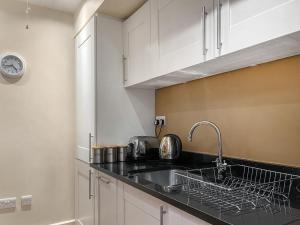 a kitchen with white cabinets and a sink at Moat House 6 - Ukc4889 in Fort Augustus