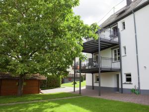 an apartment building with a balcony and a tree at Beautiful Apartment in Morscheid Riedenburg in Morbach