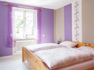 a bedroom with two beds with purple walls and a window at Beautiful Apartment in Morscheid Riedenburg in Morbach