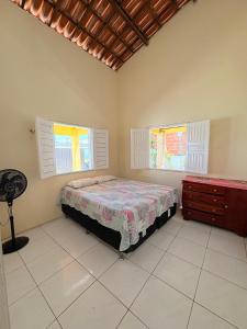 a bedroom with a bed and two windows and a dresser at Caponga Beach House - 100m da Praia in Cascavel +22 photos