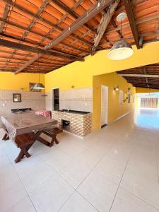 a large room with a wooden table and a pool at Caponga Beach House - 100m da Praia in Cascavel