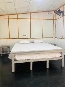 a bed in a room with a white mattress at Hobbit in Midigama East
