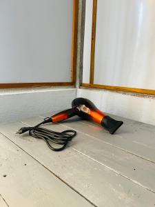 an orange and black umbrella laying on the floor at Hobbit in Midigama East