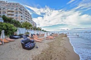a beach with chairs and umbrellas and the ocean at Seaside Sunset - free parking in Golden Sands
