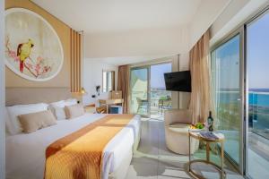 a hotel room with a bed and a balcony at NissiBlu Beach Resort in Ayia Napa