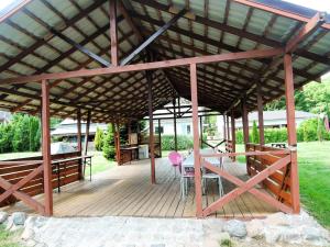 a wooden pavilion with a table and a pink chair at Holiday House in Szczecin at the lake with parking space for 4 persons in Szczecin