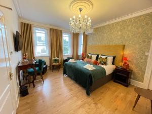 a bedroom with a bed and a table and a chandelier at Ashbys Accommodation & Spa hire in Portsmouth