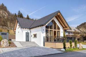 a white house with a black roof at Chalet Bela in Bohinjska Bela