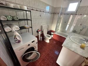 a bathroom with a washing machine and a sink at Angela Apartments in Igoumenitsa +26 photos