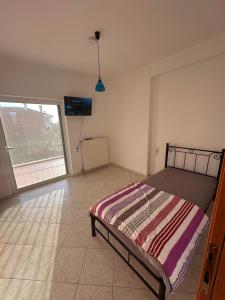 a bedroom with a bed and a large window at Angela Apartments in Igoumenitsa