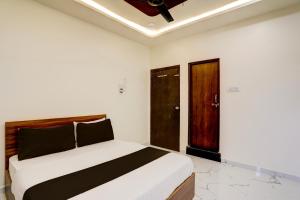 a bedroom with a large bed and a wooden door at Hotel O highway blues in Nagpur +44 photos